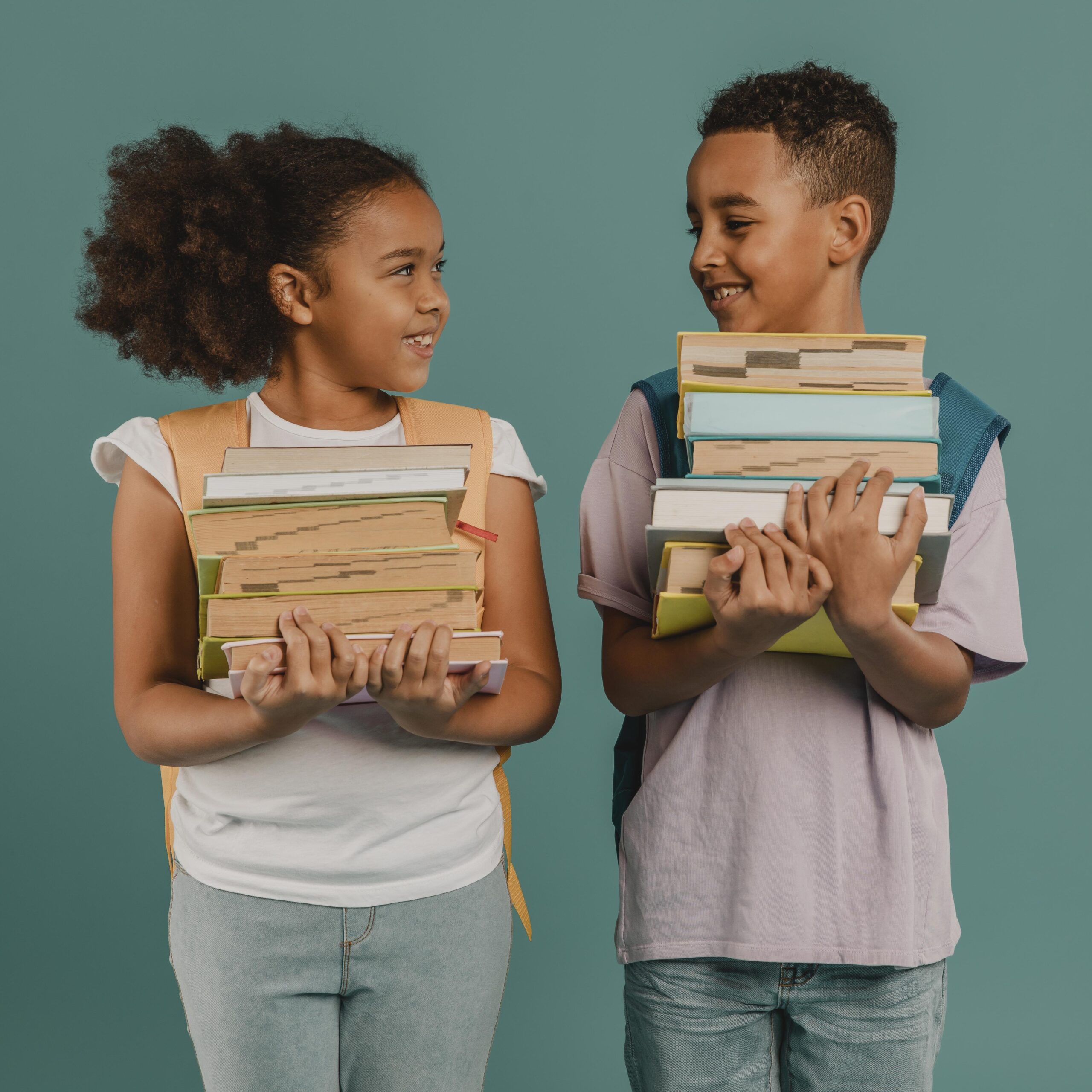 children holding piles books