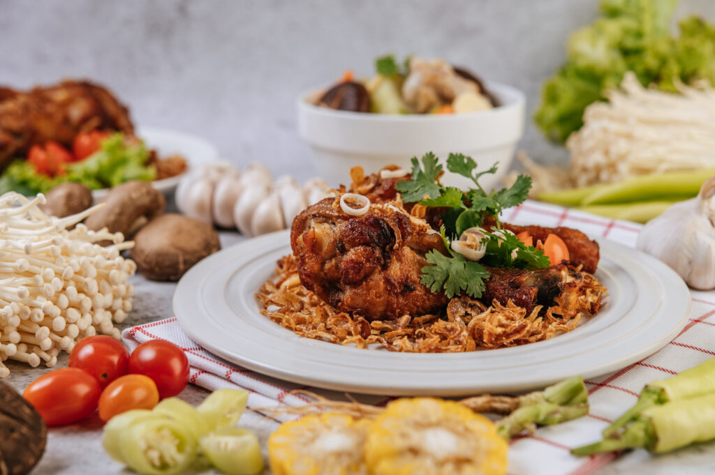 fried chicken leg with tomato, chili, fried onion, lettuce, corn
